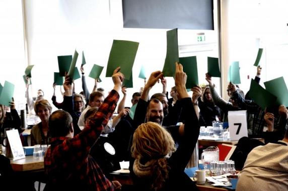 Folk til møde der holder papir op for at stemme